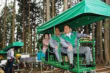 Happy Japanese businessmen ride the monorail up Mt. Honita